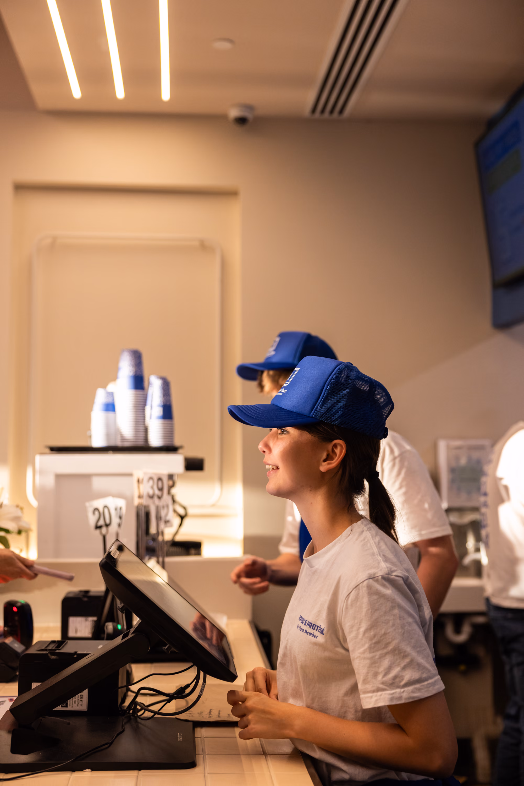 A team member serving a customer at the register