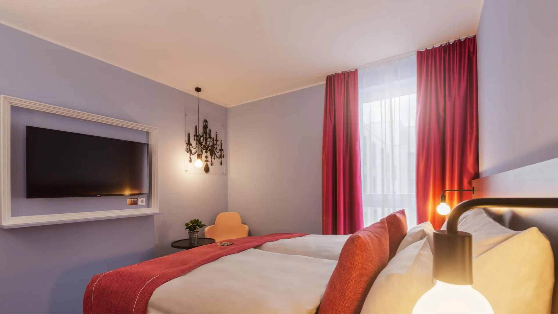 Hotelzimmer mit Fernseher und Bett