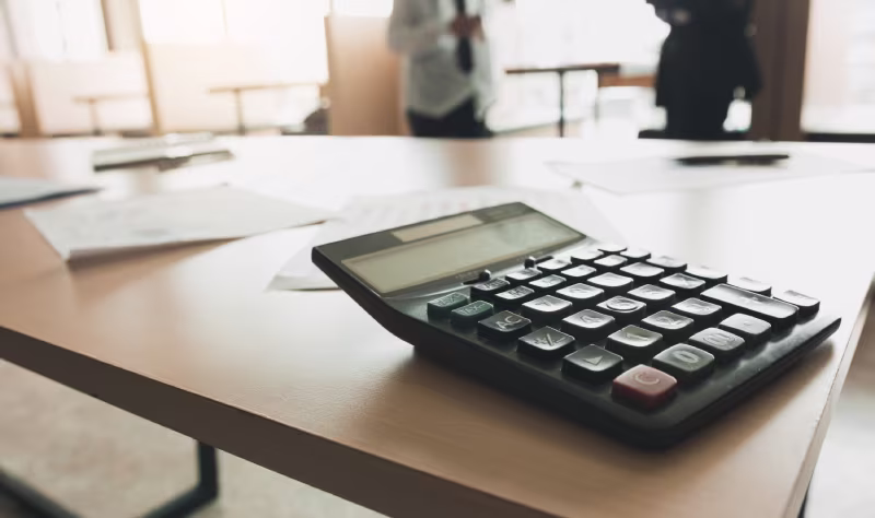  A calculator on a table in front of a desk, symbolizing financial planning for NetSuite Salesforce integration costs
