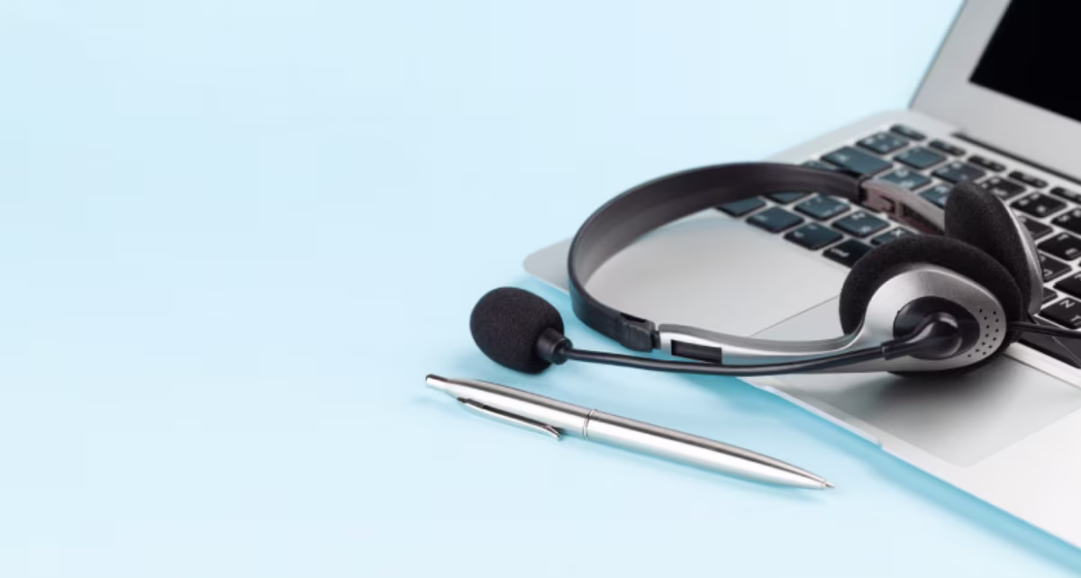 Headset and pen on a blue background, symbolizing tools for the NetSuite Health Check and improving ROI.