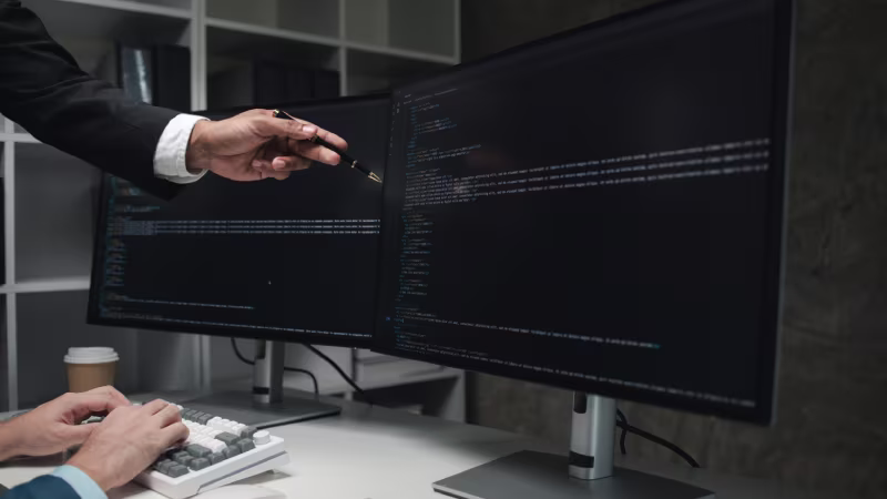 A suited man gestures towards a computer screen highlighting NetSuite Health Check features for resolving slowdowns and risks.