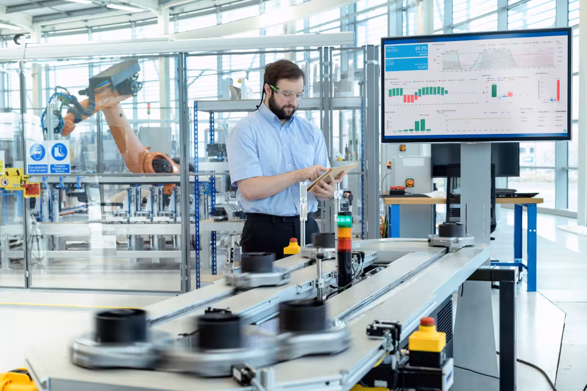 A man is engaged with machinery in a factory, showcasing the critical role of support systems in manufacturing efficiency.