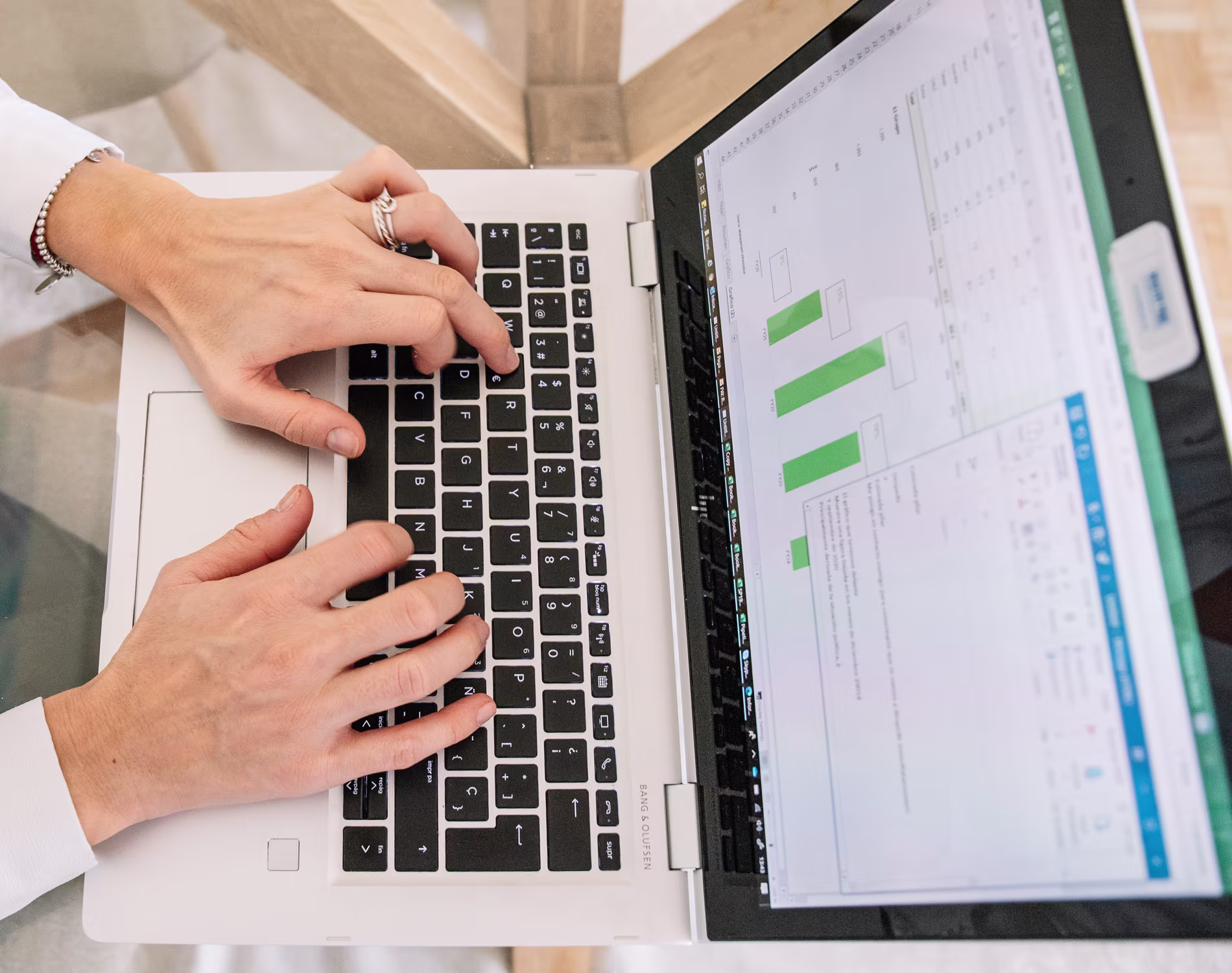 Business professional reviewing a laptop beside the headline “The Cost of Bad NetSuite Support: Five Costs Hiding in Plain Sight.