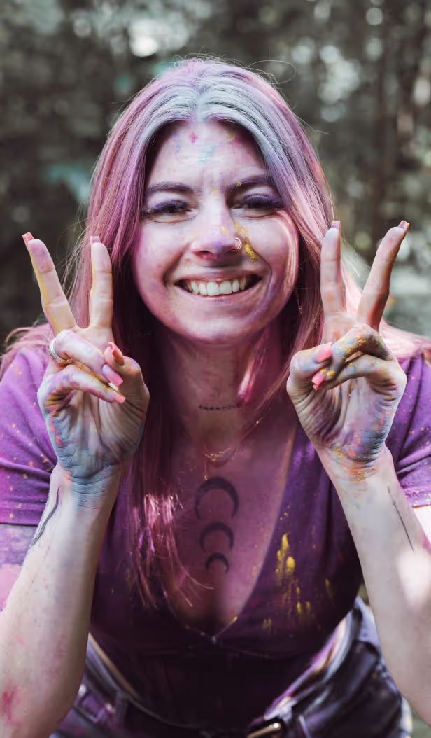 The instructor is looking into a camera with a smile on her face and showing victory sign with her hands