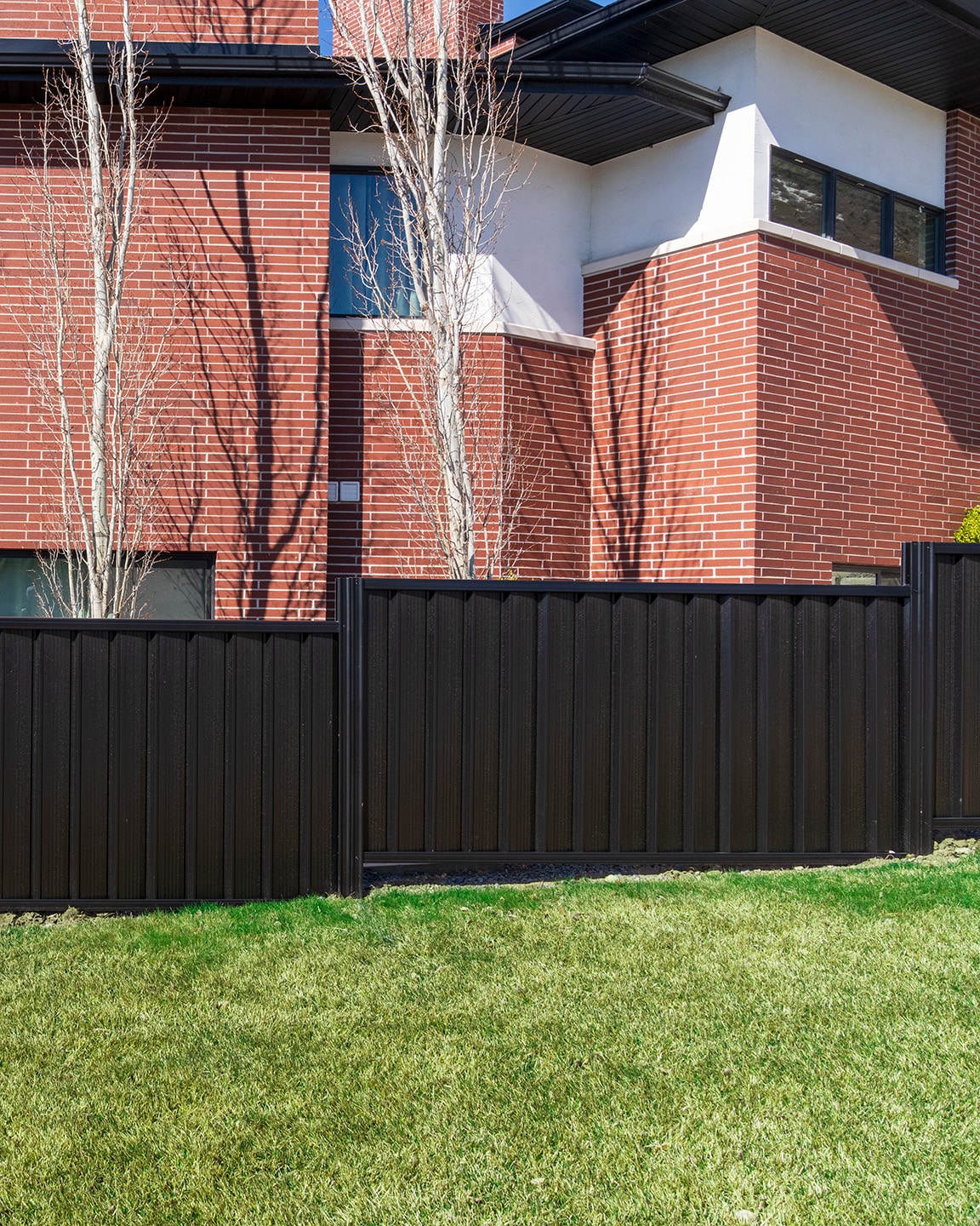 Black Colorbond steel fence installed at a modern brick home