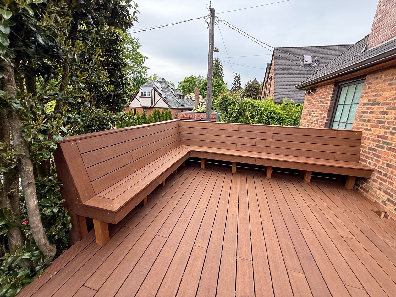 New Bellevue composite deck built by Optima Fence & Deck featuring rich brown boards and custom built-in bench seating for a modern, low-maintenance outdoor space