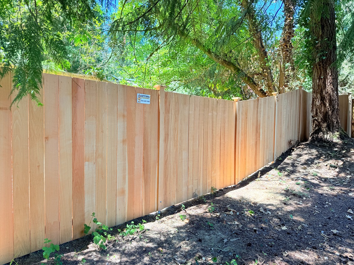 Estate fence with evenly spaced vertical cedar boards, decorative top caps, and a clean, modern design