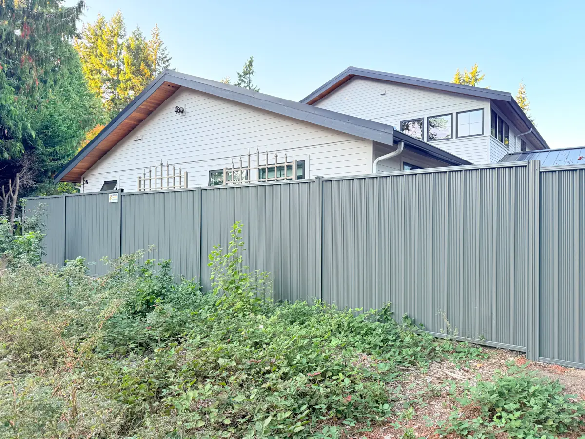 Tall gray ColorMax steel fence installed for privacy at a Bellevue residential property.