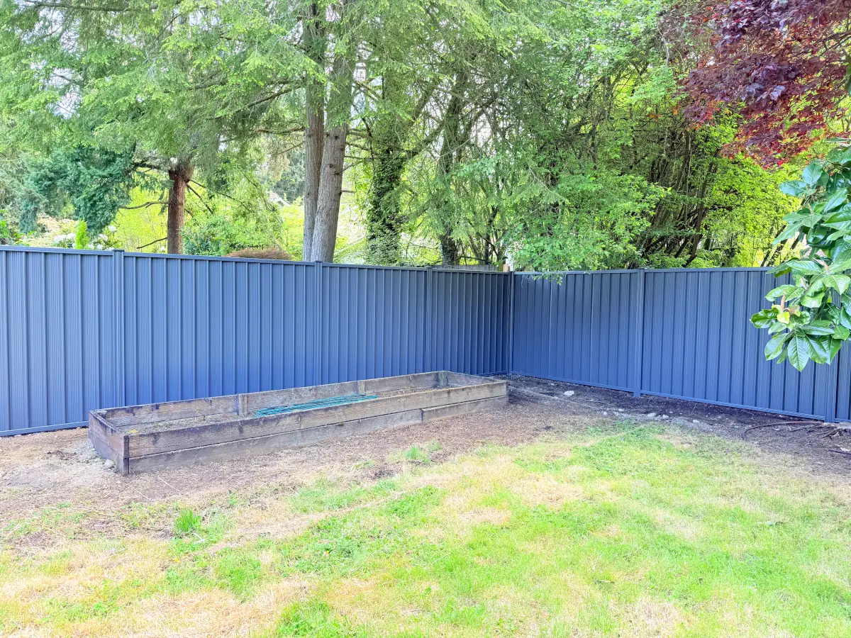 Secure and low-maintenance ColorMax metal fence surrounding side exterior of suburban home.