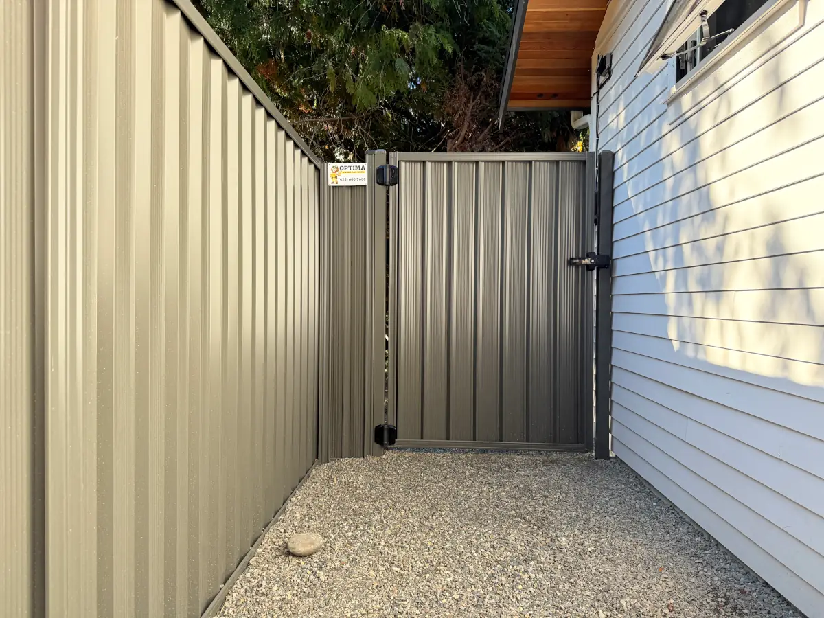Weather-resistant ColorMax steel fencing installed beside contemporary two-story house.”