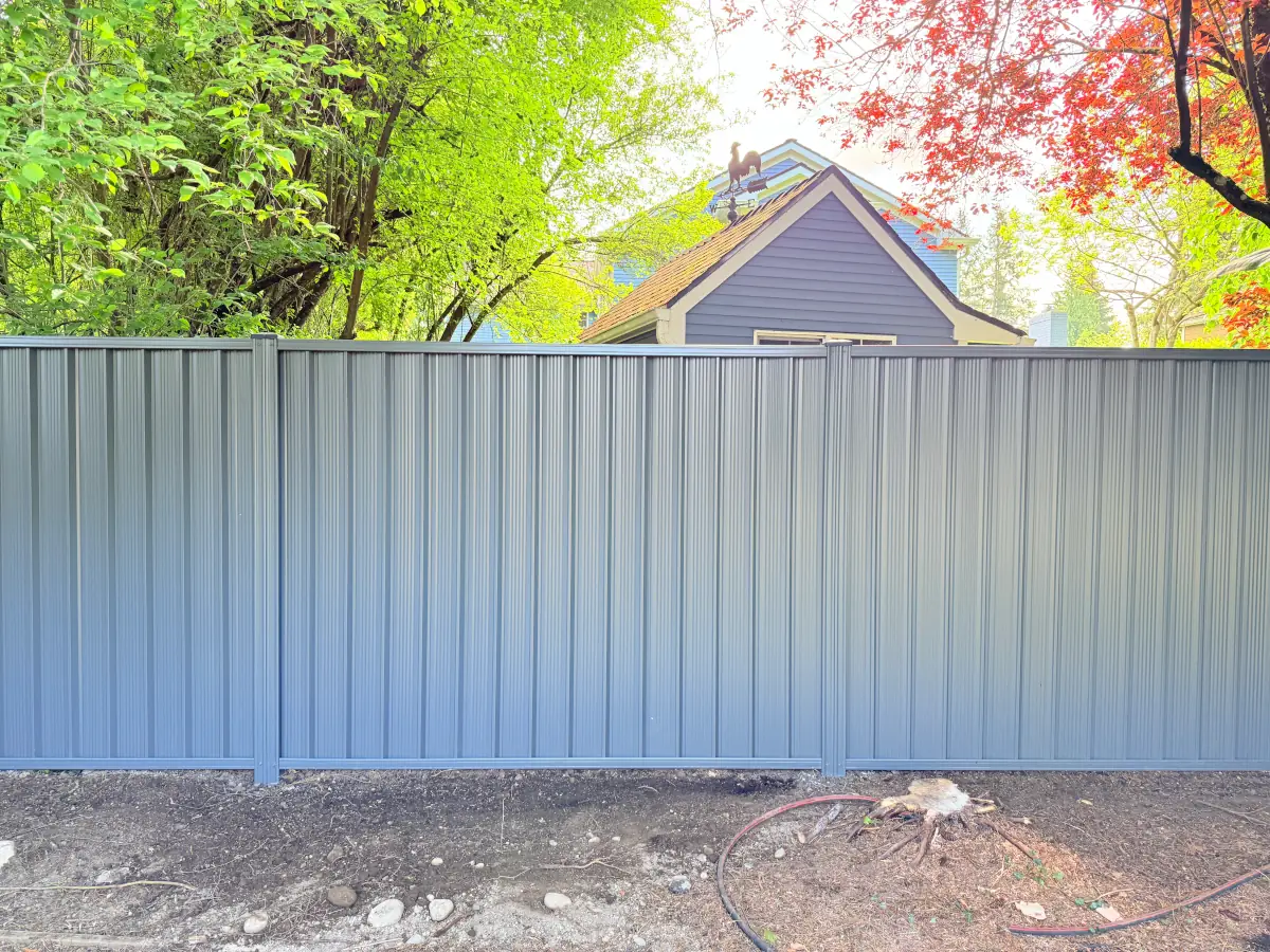 Weather-resistant ColorMax steel fencing installed beside contemporary two-story house.