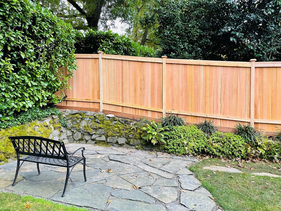 Back view of a modified full panel cedar fence installed along a landscaped garden