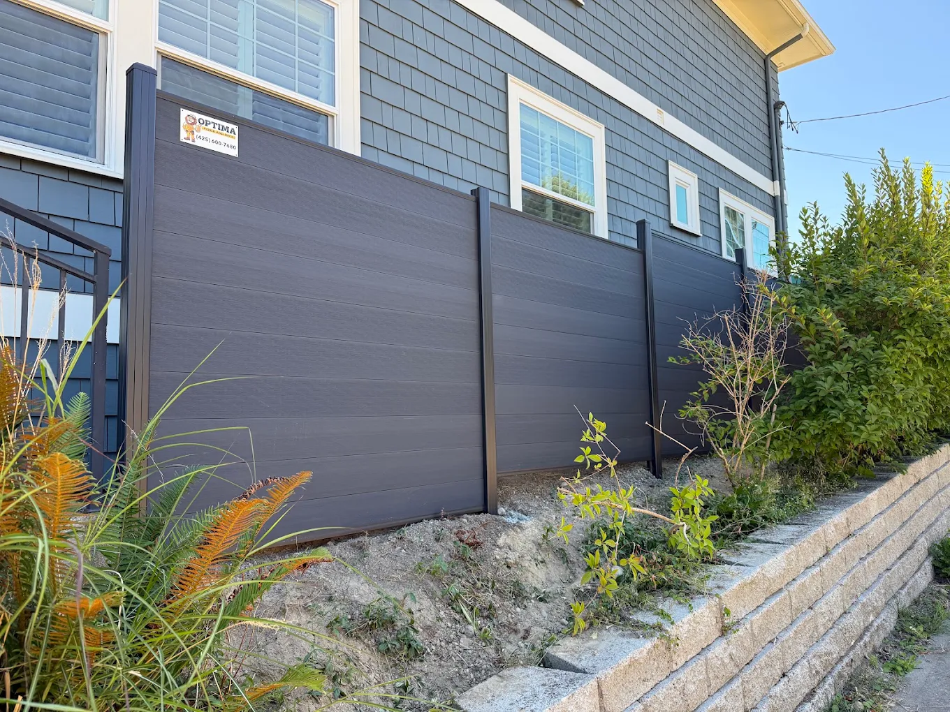 Horizontal vinyl fence panels installed in a modern residential backyard showcasing clean board-on-board design and reinforced post system
