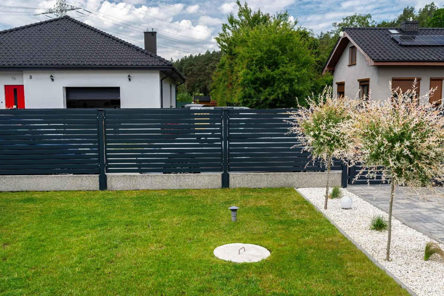Modern charcoal-colored horizontal vinyl fence panel with clean lines and a sleek contemporary design along a residential property