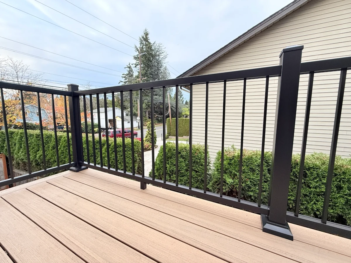 Finished composite deck with black aluminum railing overlooking backyard in Kirkland WA