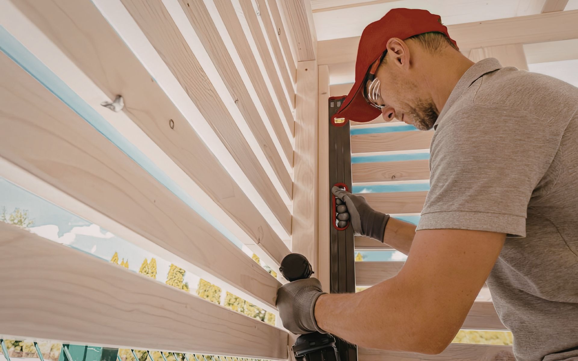 Man installing wooden slats on a fence