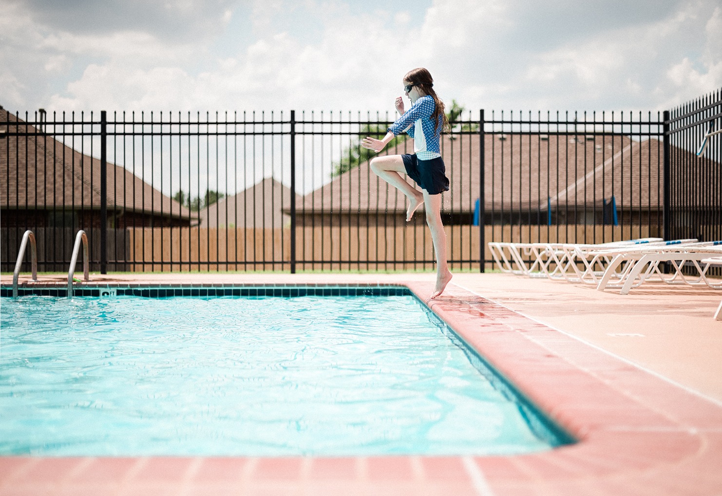 Aluminum pool fence meeting pool fence requirements around backyard pool