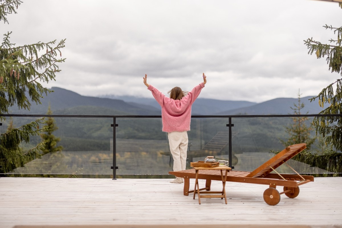 Woman enjoying the view from a Bellevue deck secured by glass panel railing