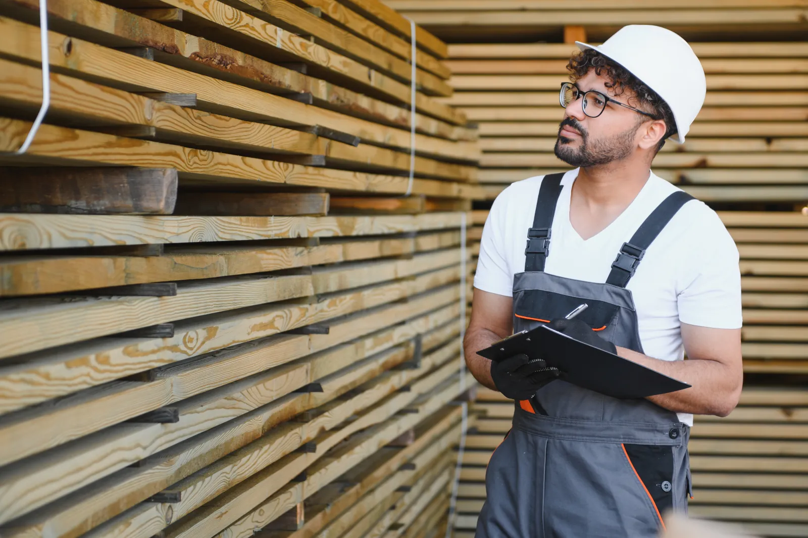 Woodworker inspecting cedar fence materials in a warehouse before ordering