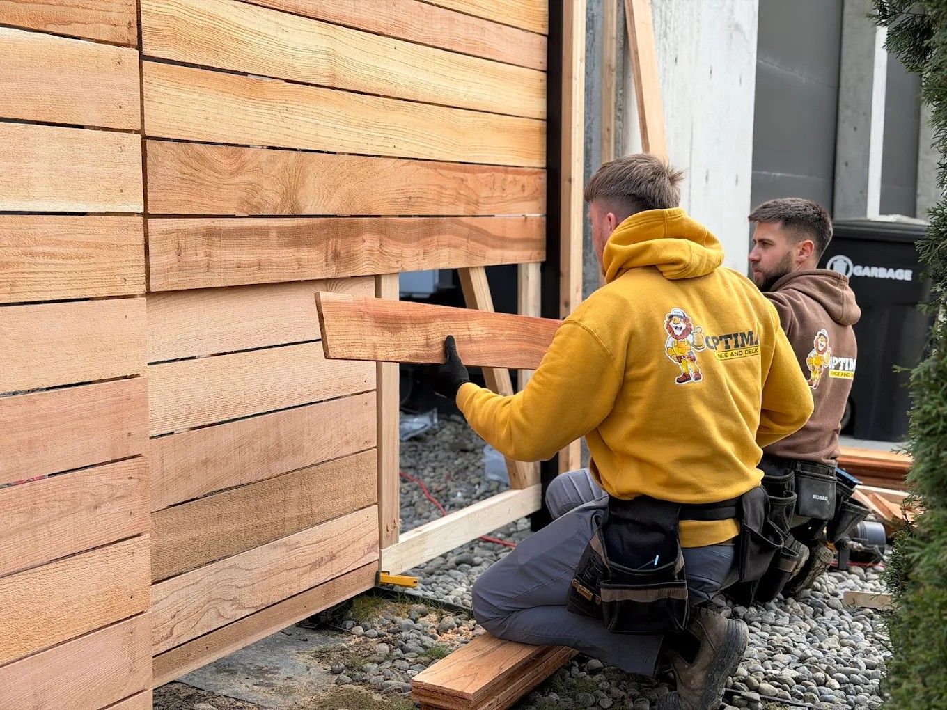 Contractors building wooden fence while using stainless steel nails in Seattle