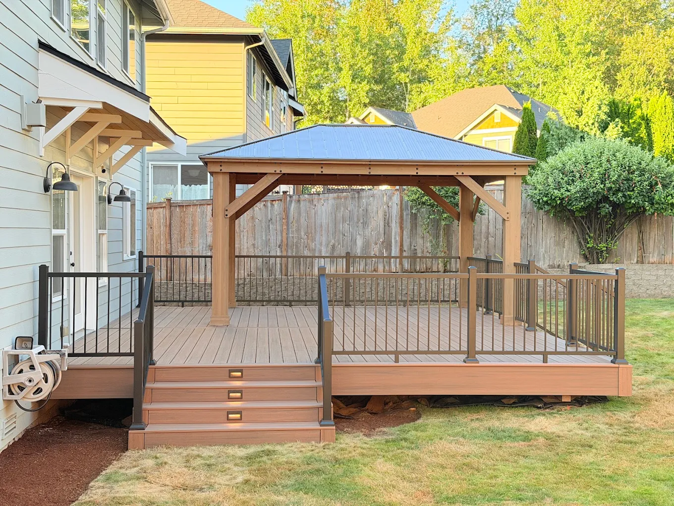 Newly built covered composite deck on a Bellevue home with metal railings