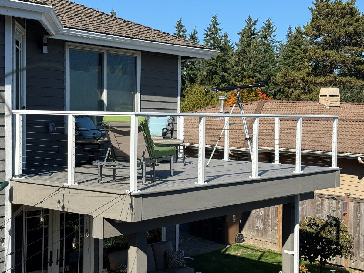 A composite deck with cable railing situated on a Bellevue home's second story
