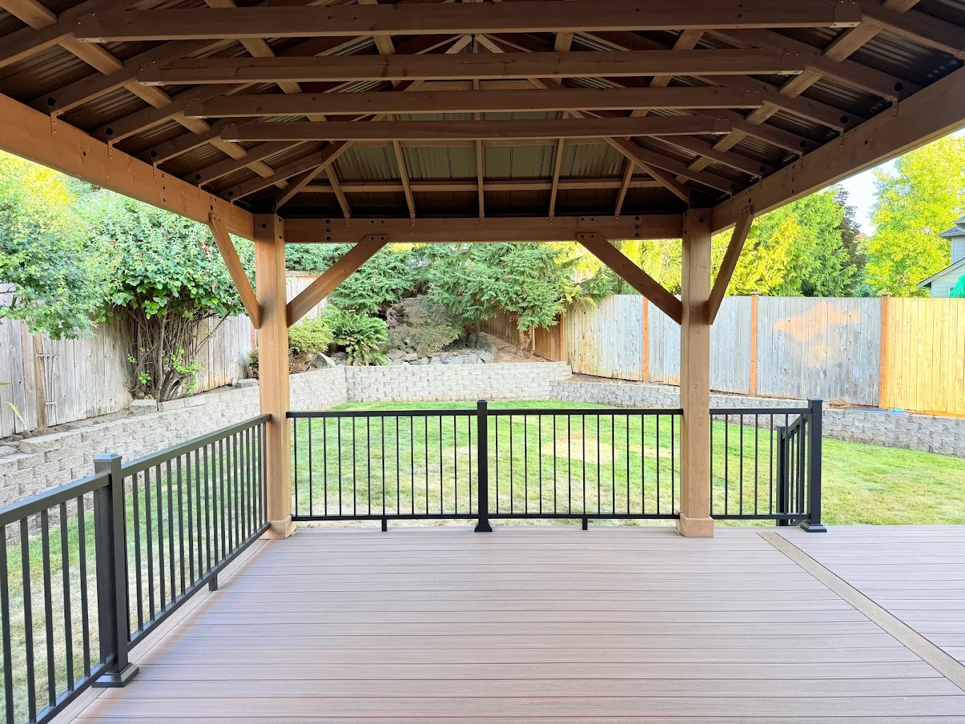 View from inside a covered deck structure in Bellevue looking out over the backyard