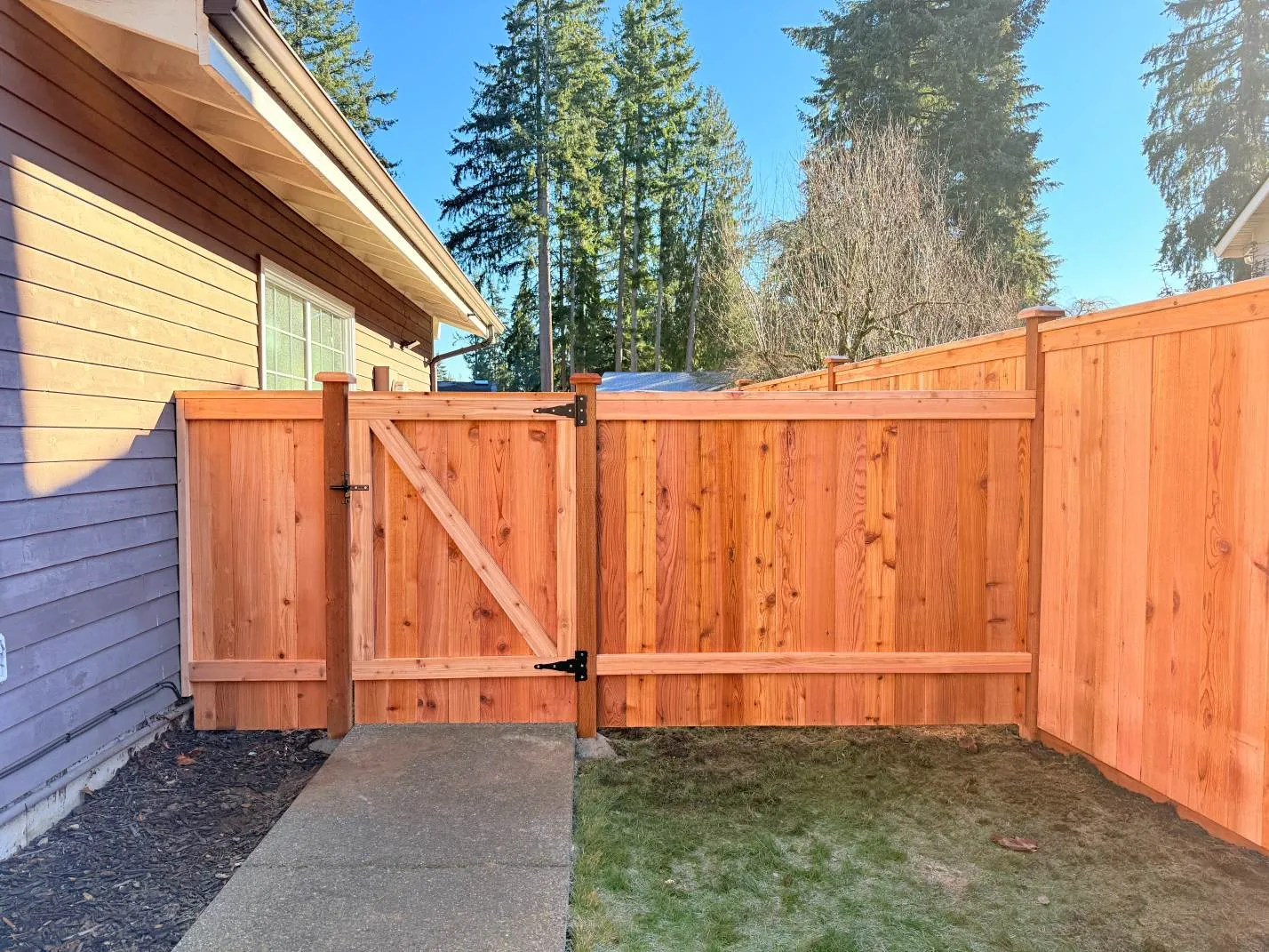 Custom backyard fence installation completed with high-quality cedar panels