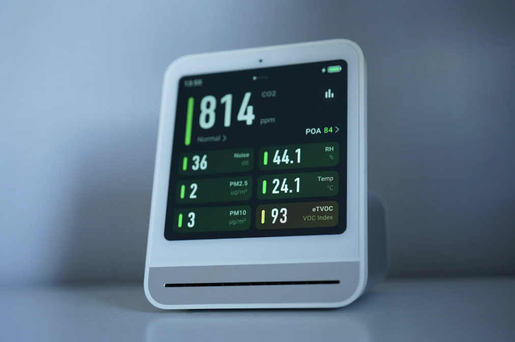 alt text: Smart thermostat displaying indoor temperature and humidity
