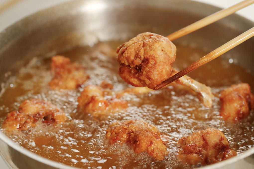 alt text: Dog being fed oily table scraps that can trigger pancreatitis