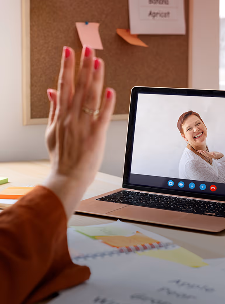 A woman waving at a woman on a web conference