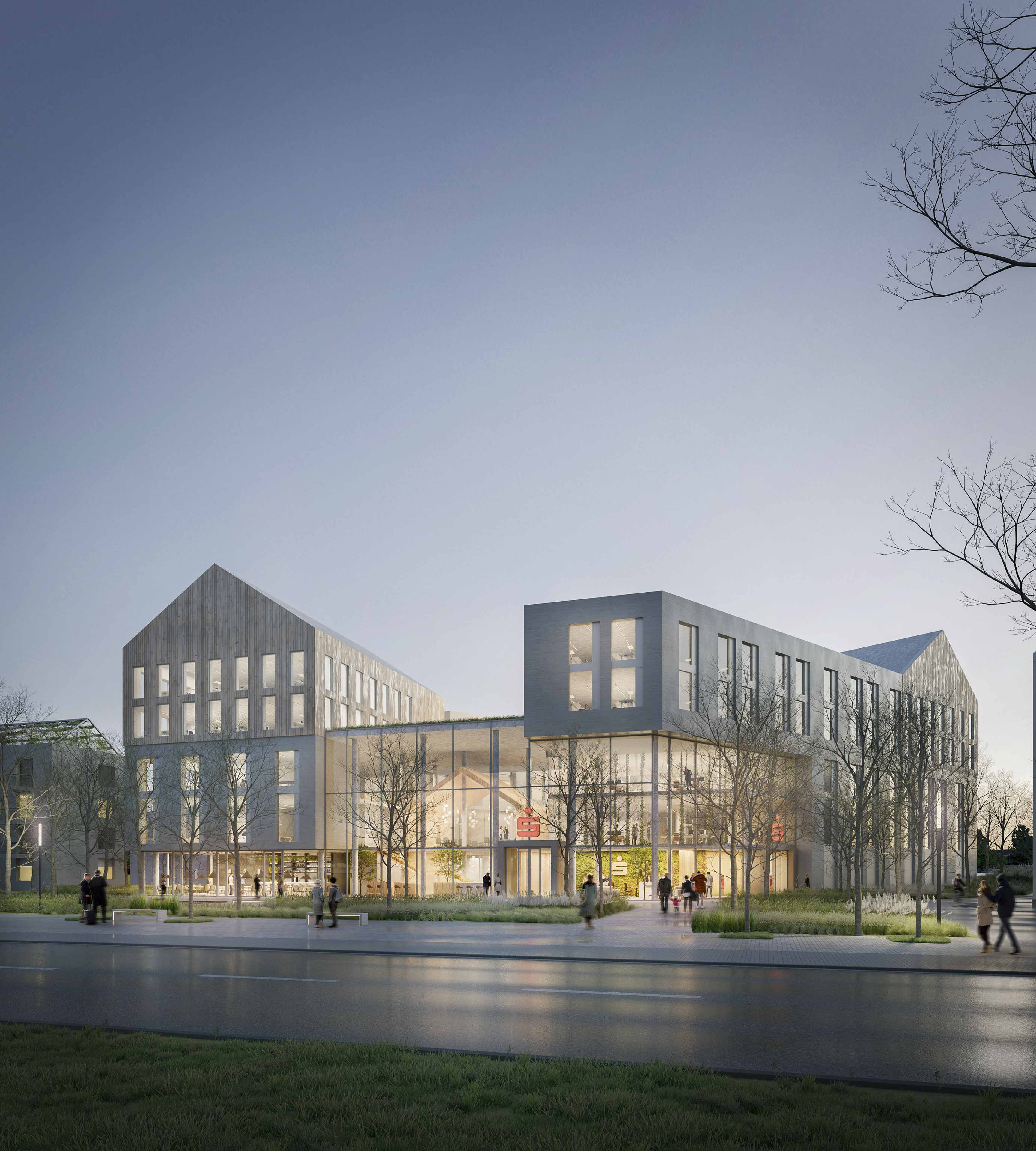 Modernes Gebäude mit Glasfassade und beleuchtetem Innenraum, umgeben von Bäumen und Gehweg, bei Abendlicht.