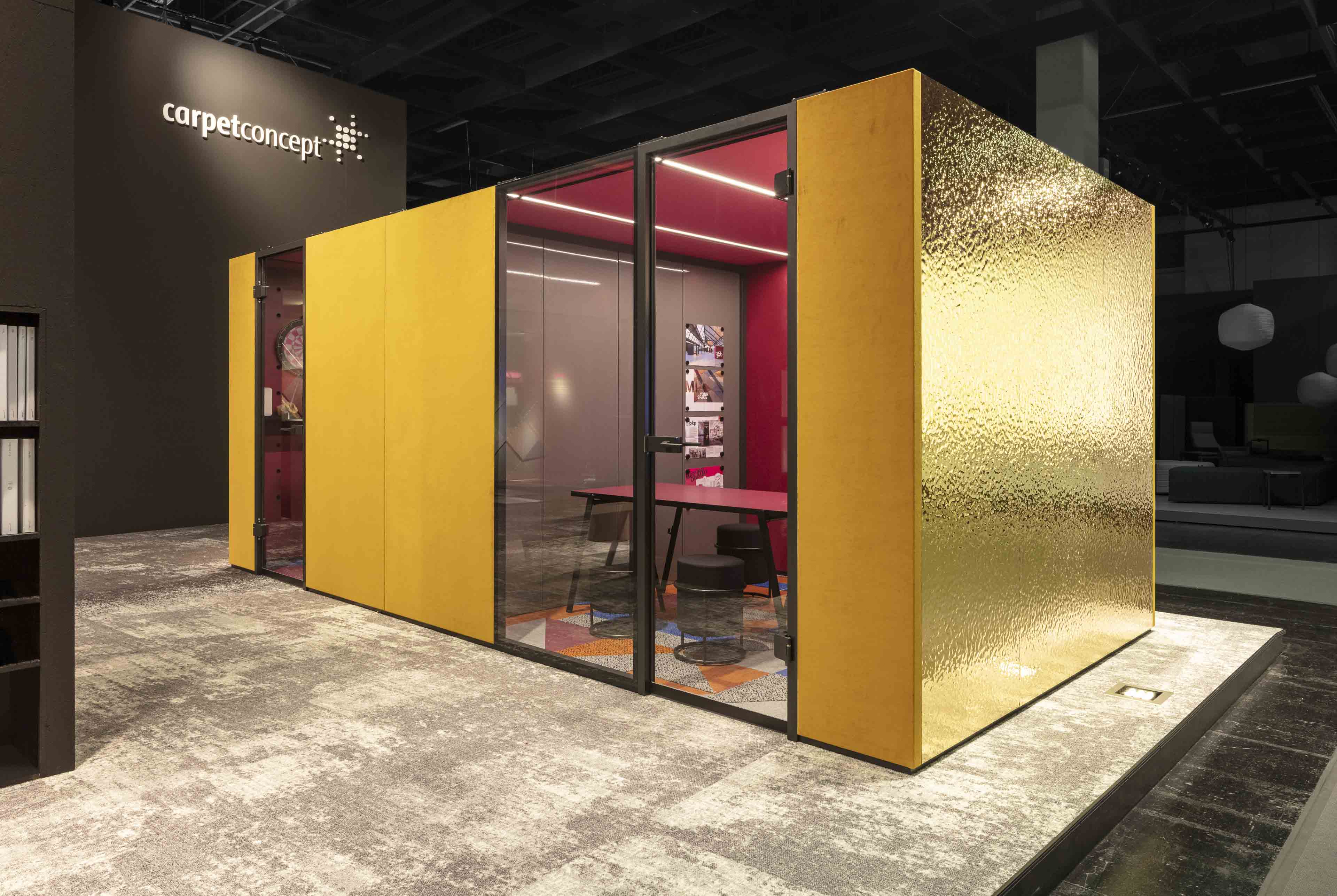 Moderner Besprechungsraum mit goldener und gelber Außenwand, Glasfront und roten Wänden im Inneren.