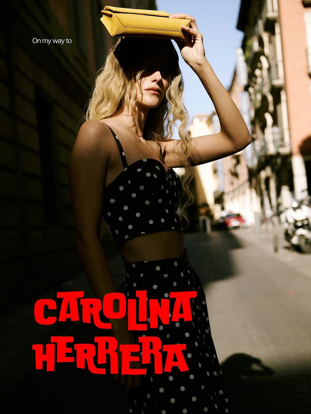 Older man wearing dark sunglasses and a navy sweater sitting at a table, holding a white gift box with a red ribbon, with text saying 'Sunnies that say "I know what I like"'.