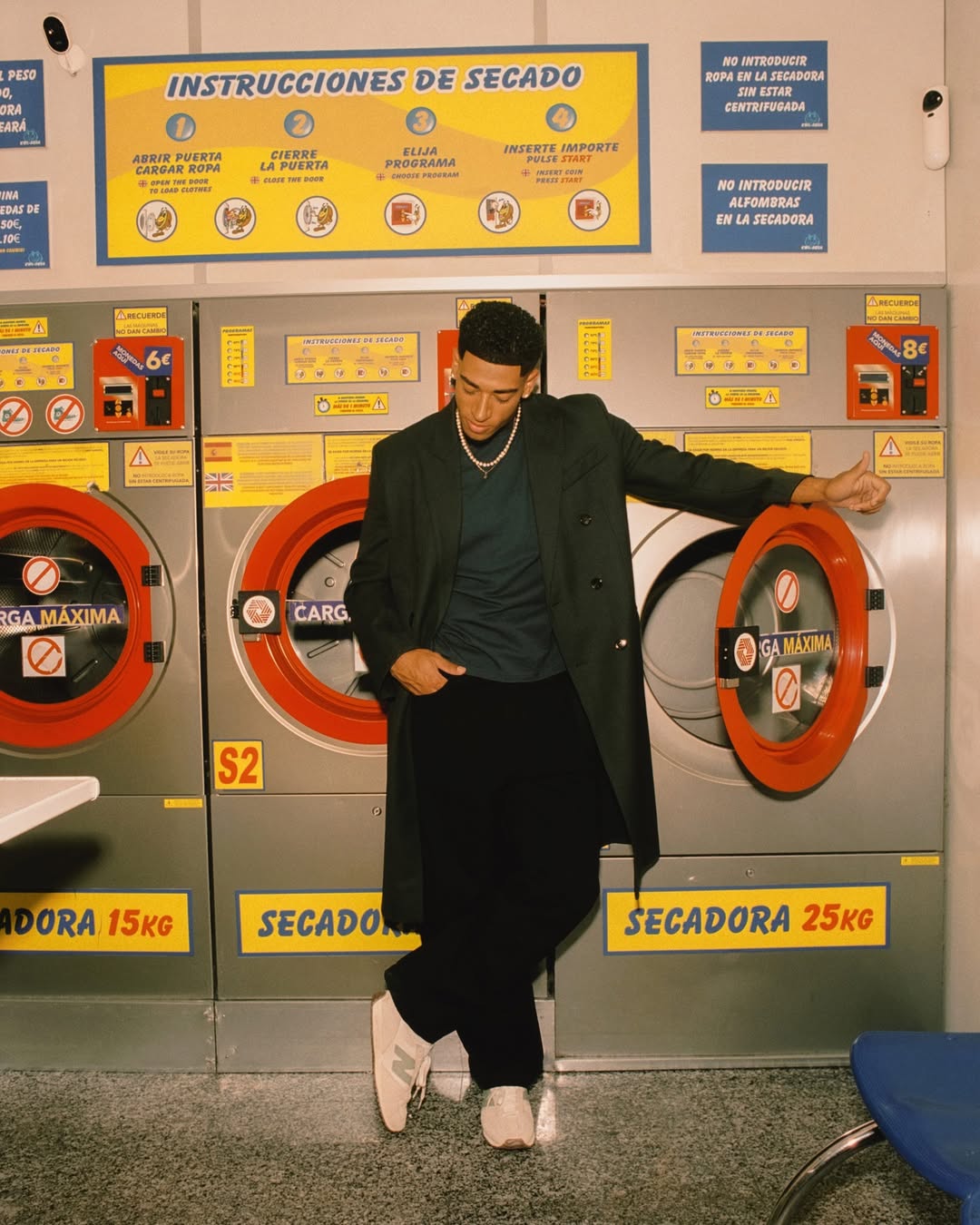 Older man wearing dark sunglasses and a navy sweater sitting at a table, holding a white gift box with a red ribbon, with text saying 'Sunnies that say "I know what I like"'.
