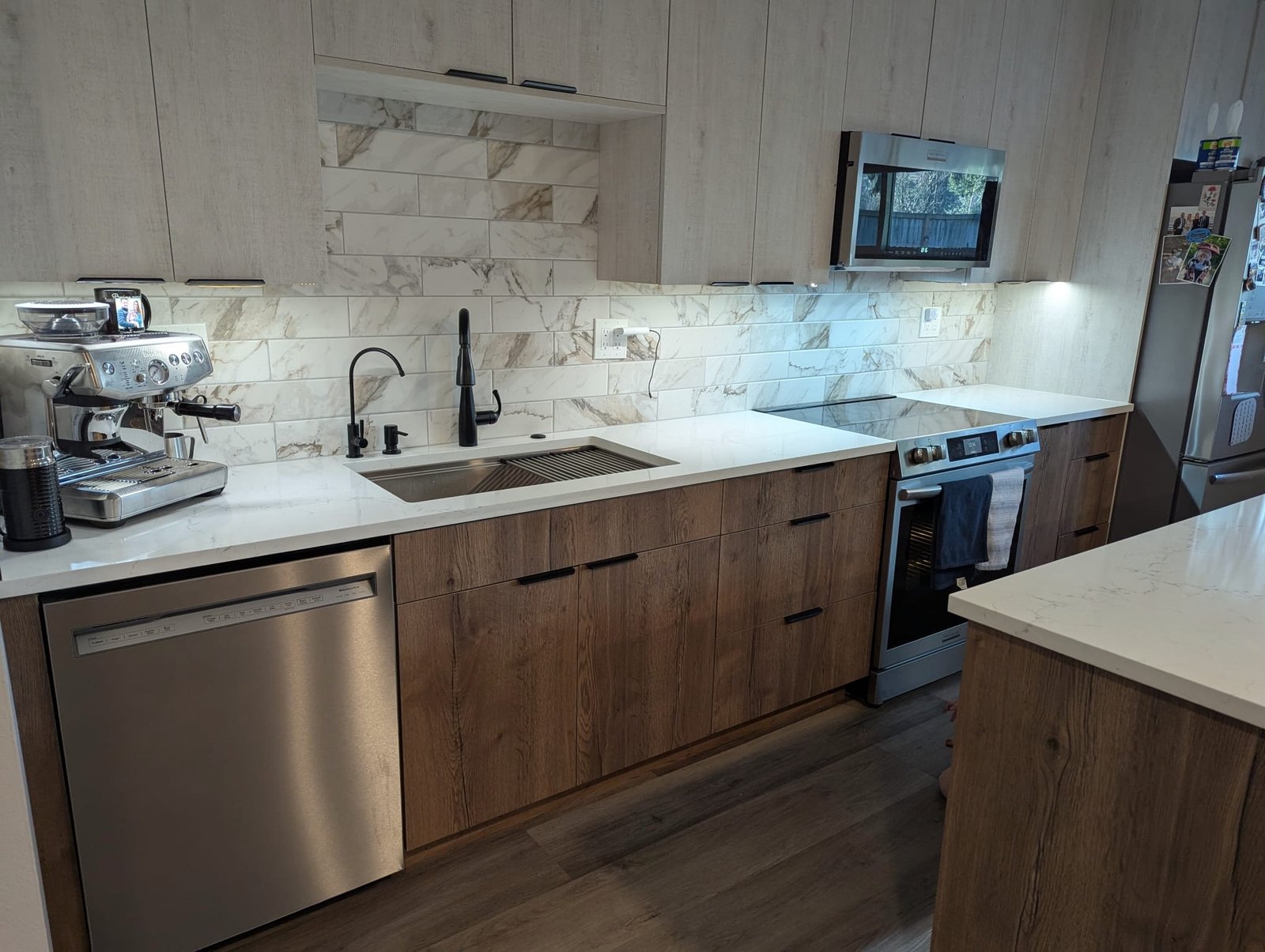 Walnut kitchen cabinets with marble backsplash and quartz countertops in a Seattle remodel.