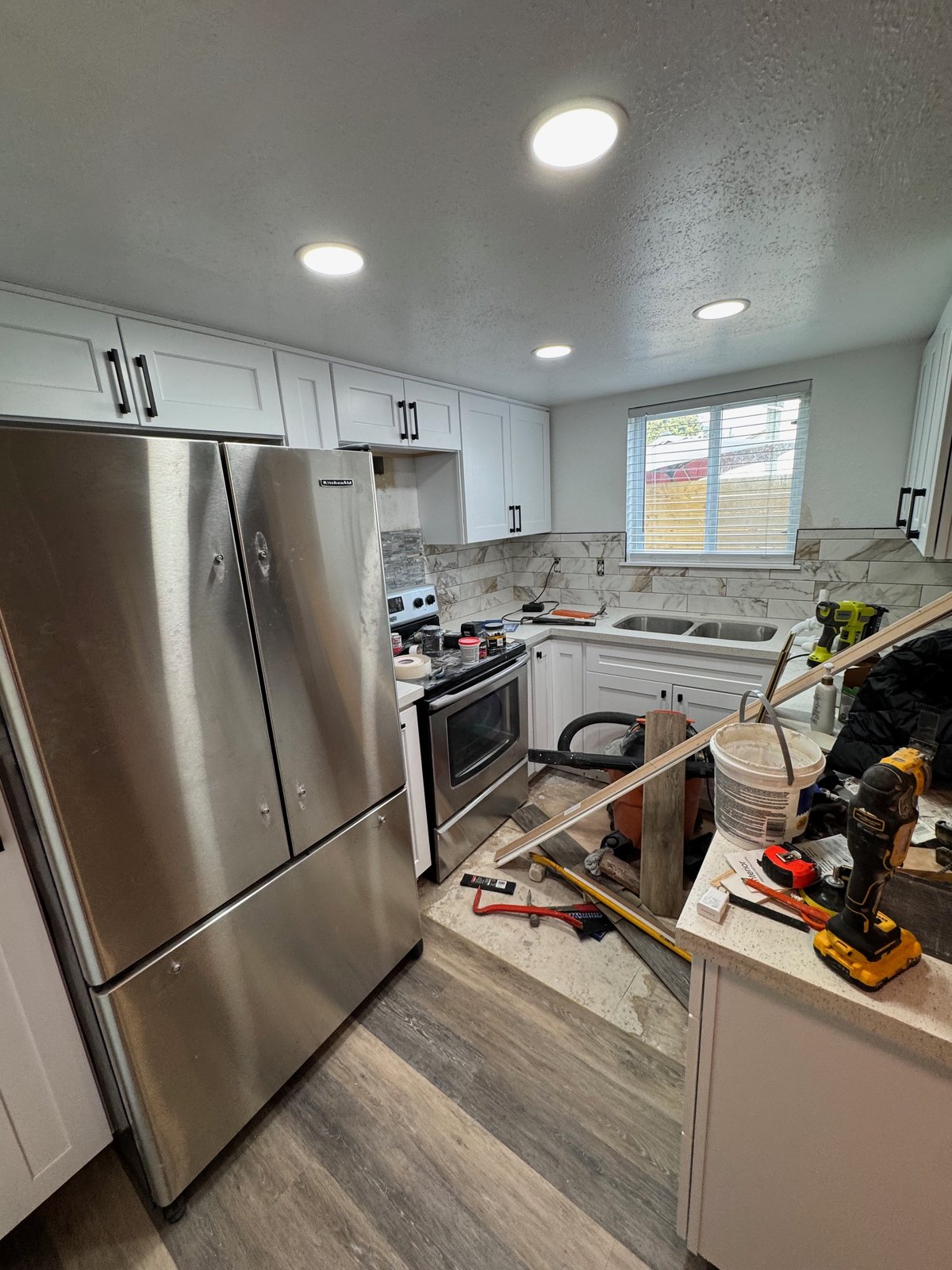 Stainless steel refrigerator, range and microwave installed in a finished Seattle kitchen remodel.