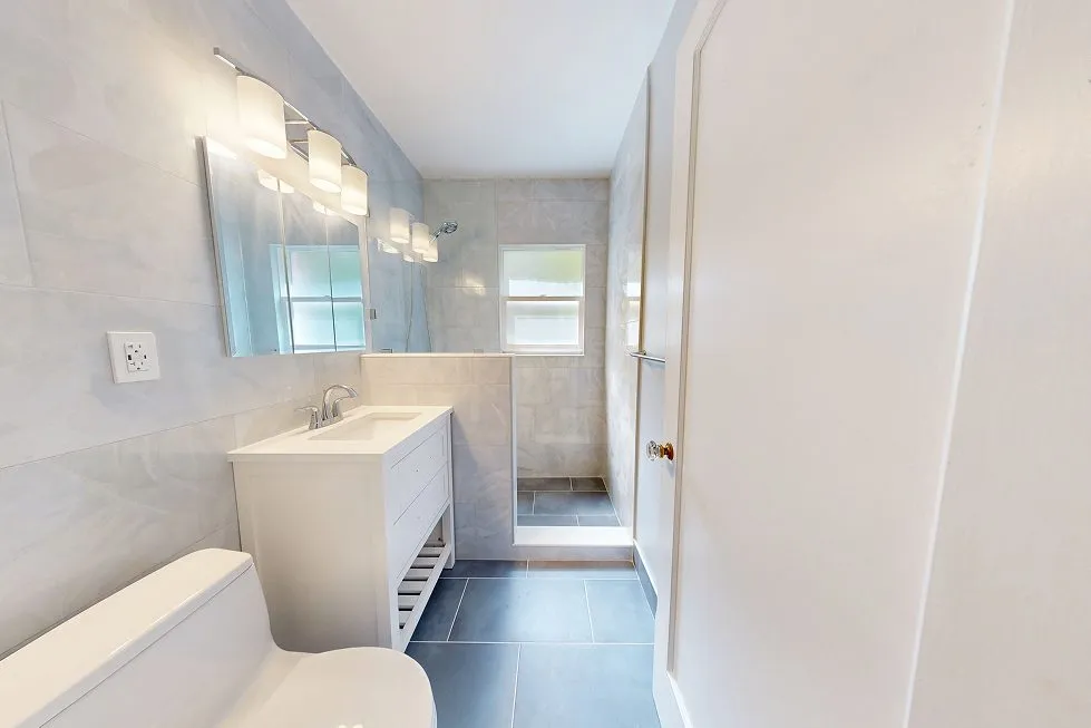 Finished Capitol Hill bathroom with a white vanity, walk-in shower and slate-blue porcelain floor