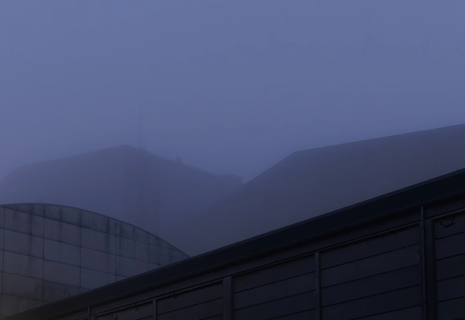 Misty mountains behind a modern building structure
