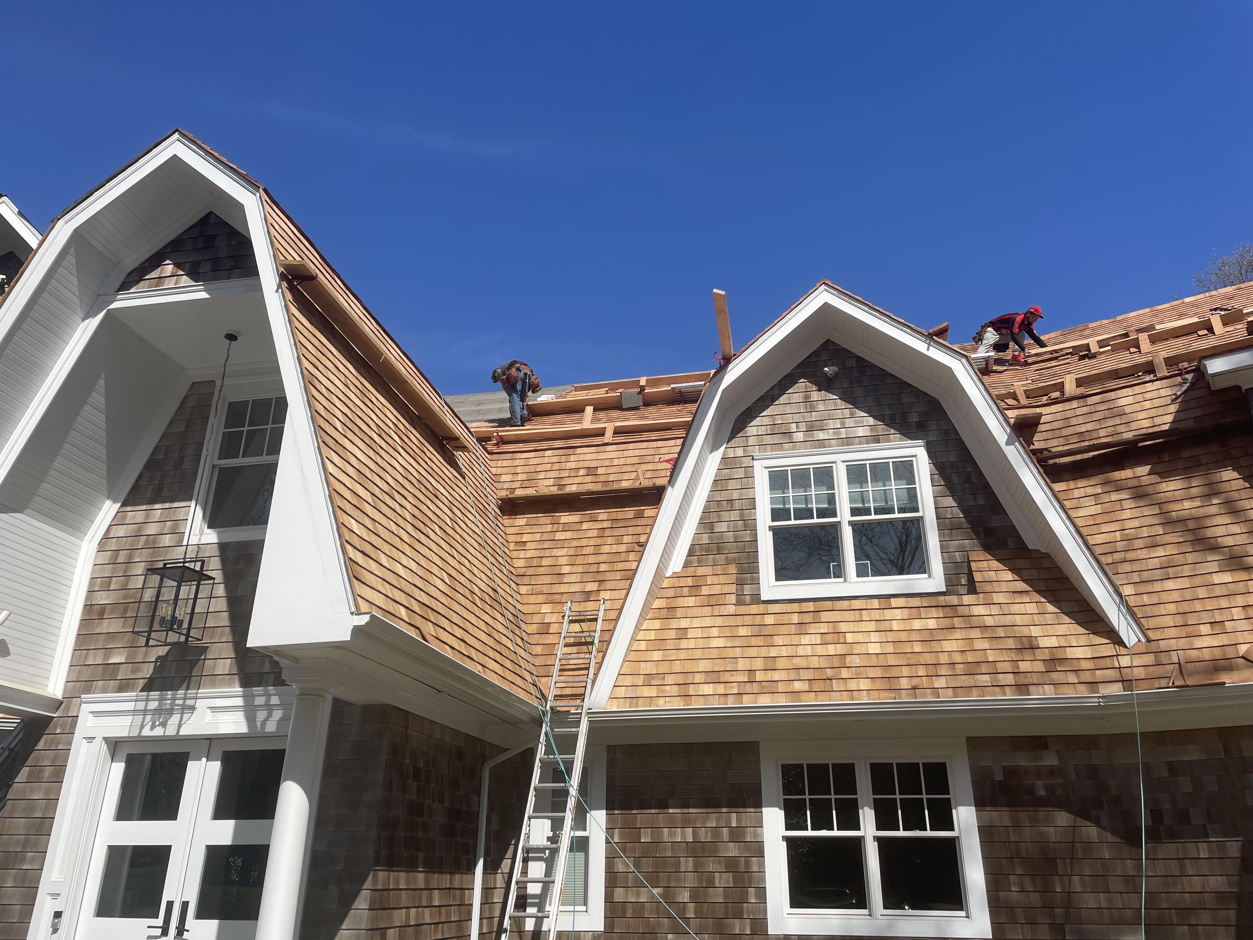 Partial roof replacement in progress, showing exposed wooden framing and new shingles being installed on a residential home.