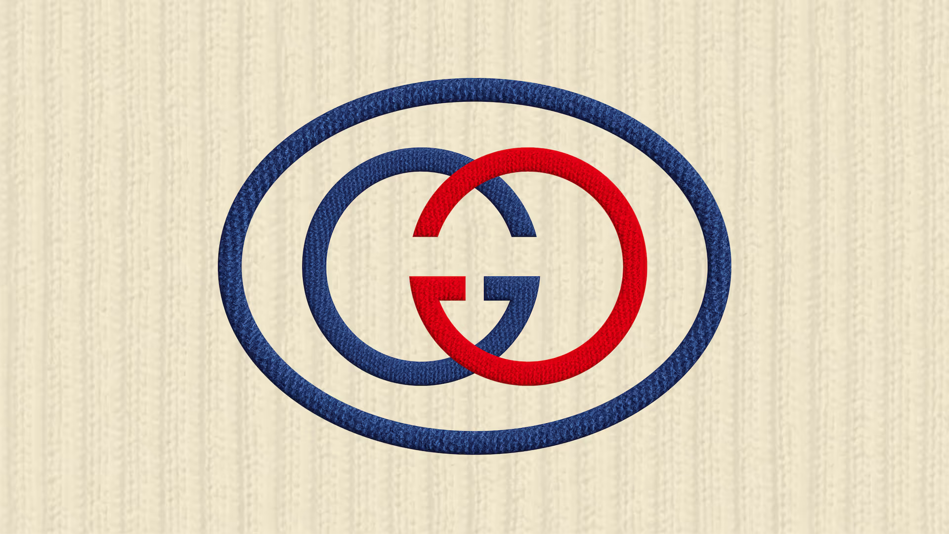 An intertwined red and blue Gucci logo with overlapping ovals, displayed on a ribbed cream fabric background.