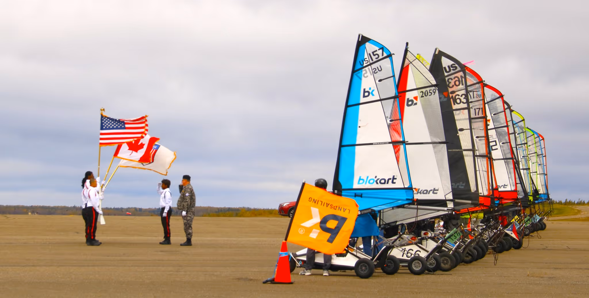 Land sailing competition with flags and blokart wheeled sailboats on runway