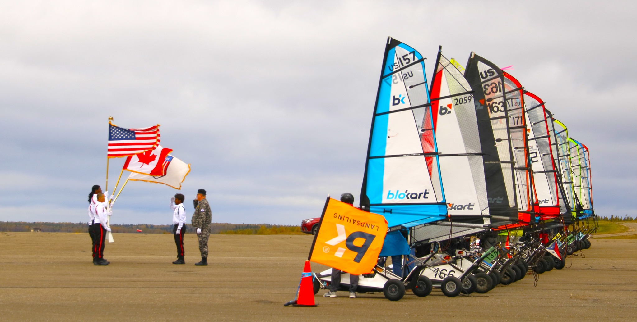Land sailing competition with flags and blokart wheeled sailboats on runway