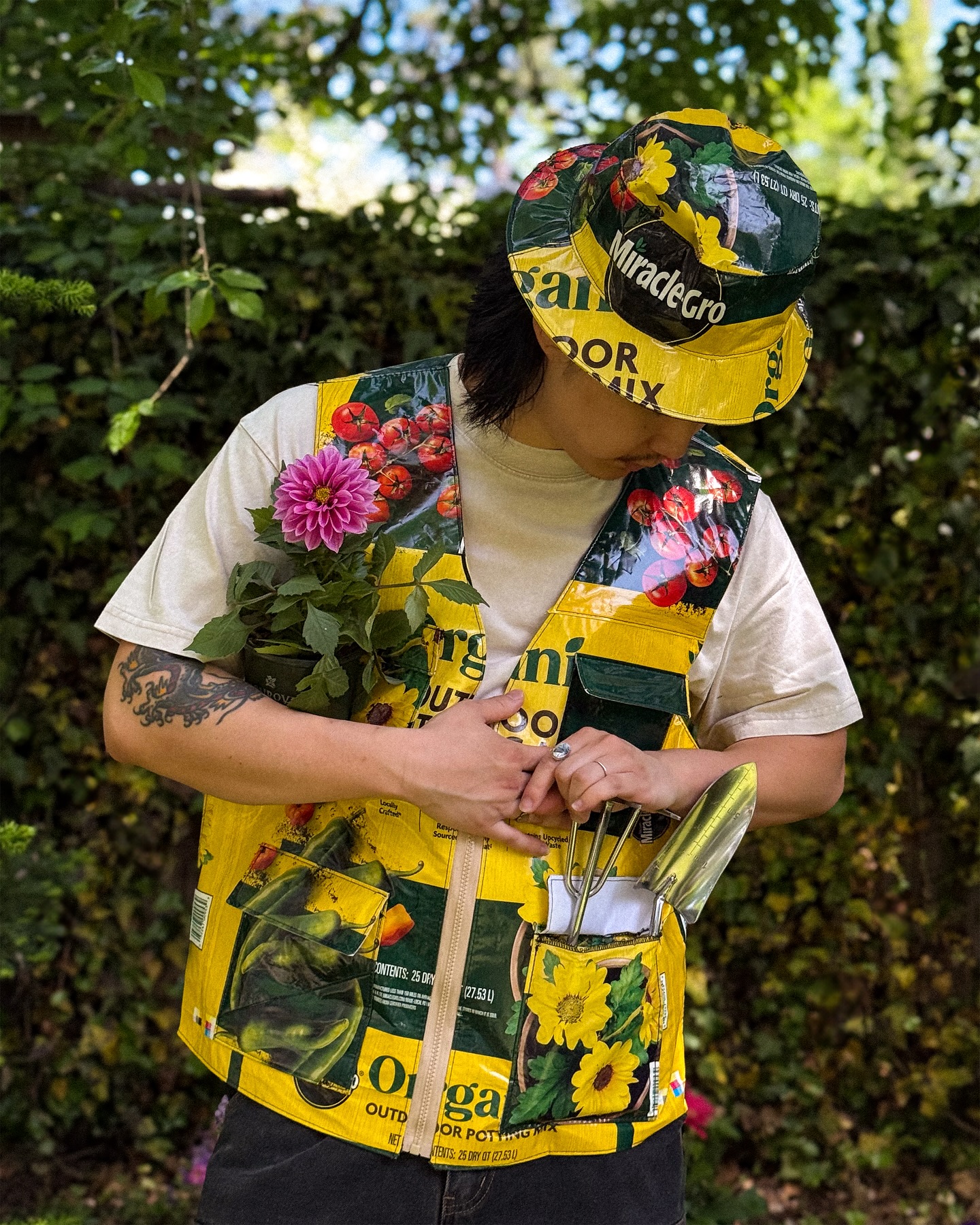The custom Miracle-Gro bucket hat and pocketed vest worn together in the garden