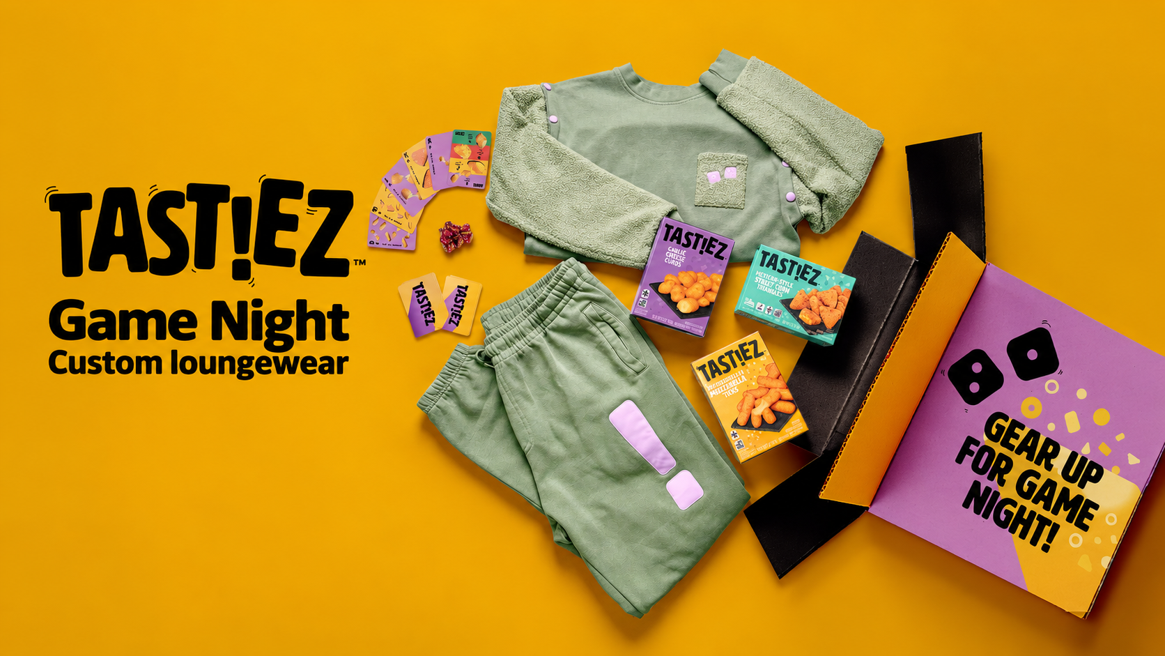 TAST!EZ Game Night custom green sweatsuit with textured sleeves and lavender details, arranged beside the purple game-night box, snacks, and playing cards