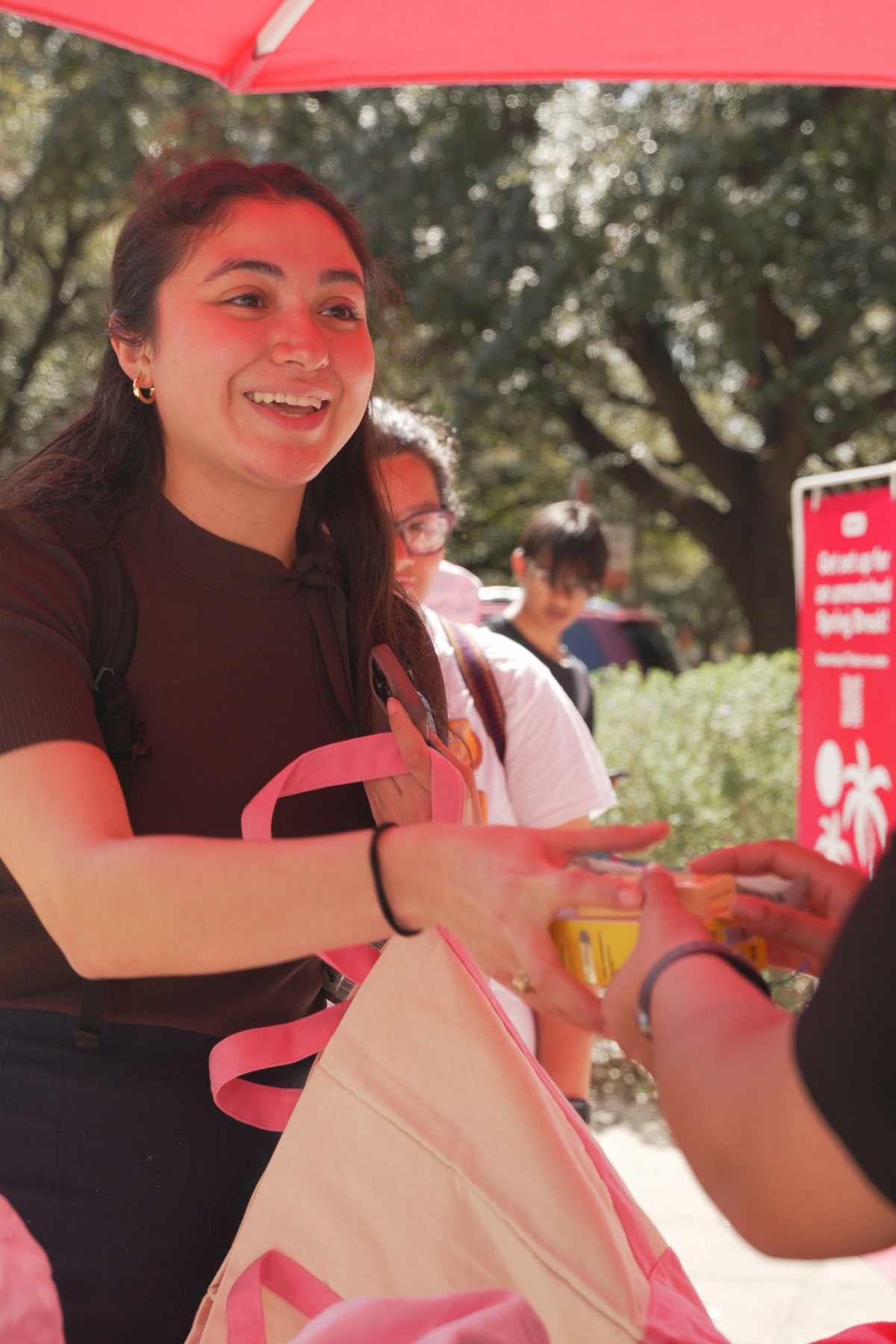 A student carrying the cream-and-pink Spring Heart Breaker Tinder tote