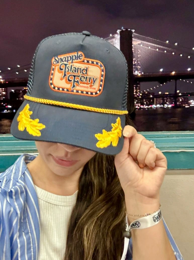 An event guest wearing the navy Snapple Island Ferry cap on the waterfront
