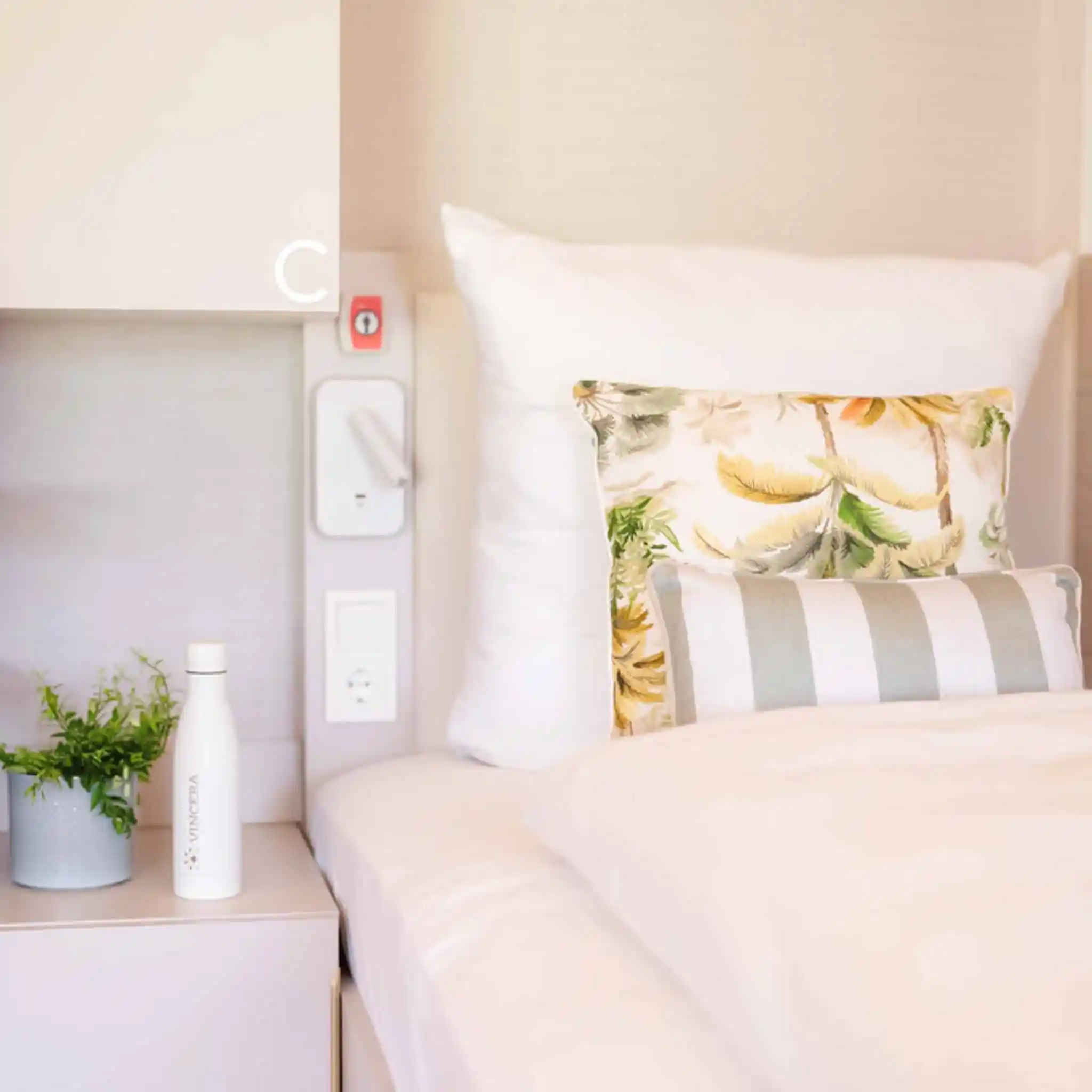 Aufnahme der linken Seite des Kopfteils eines Bettes sowie des danebenstehenden Nachttisches.