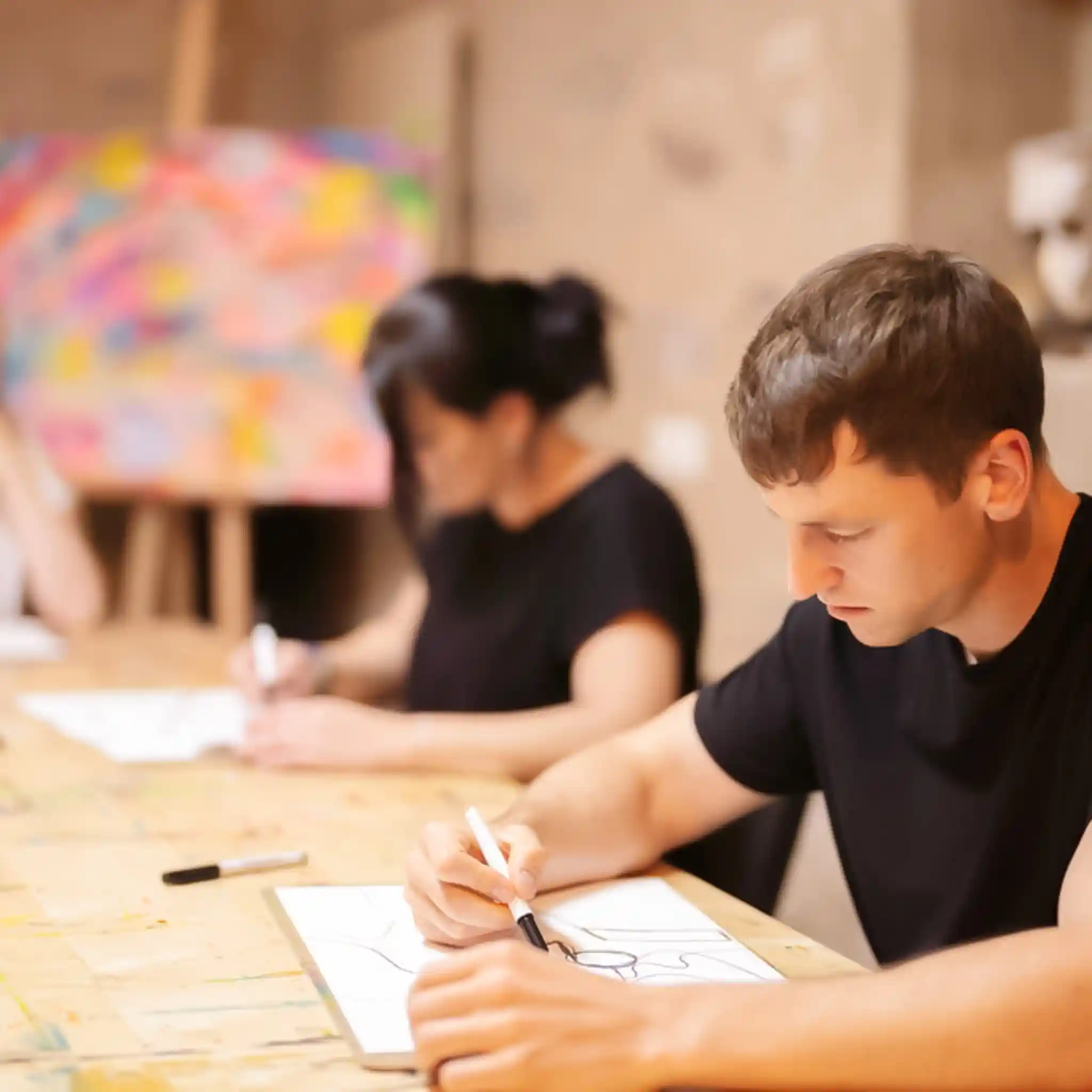 Zwei Patienten malen Bilder im Rahmen der Kunsttherapie.