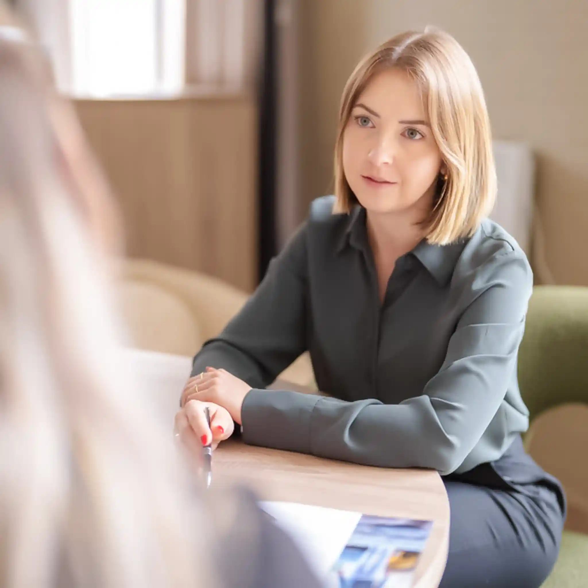 Eine Patientenmanagerin und eine Patientin gehen gemeinsam die Infomaterialien der Kliniken durch.